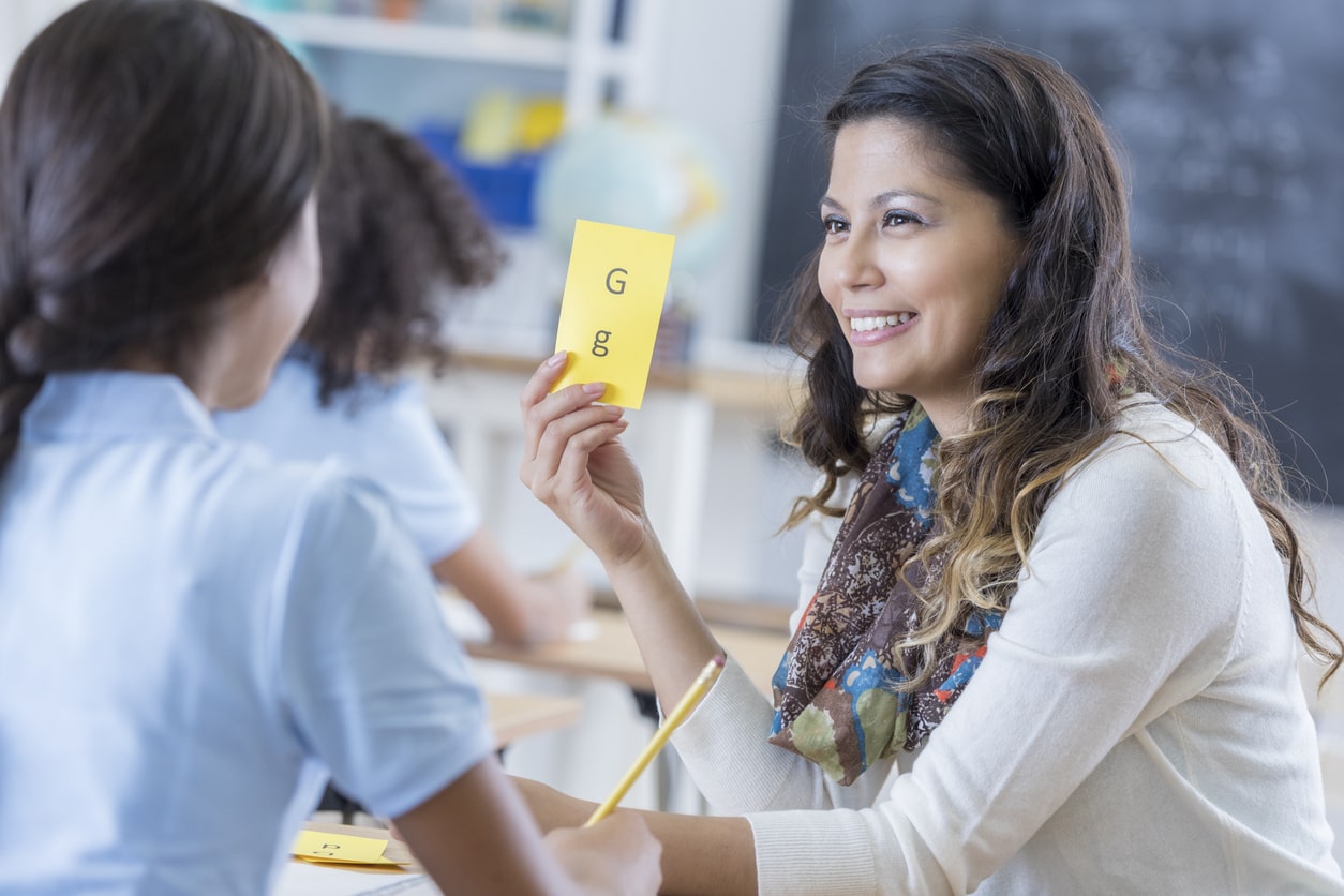 Special education teacher helps dyslexic student. Teaching students with special needs.